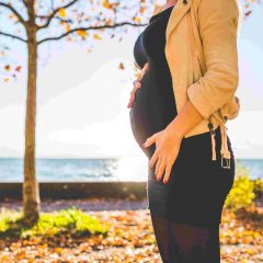 pregnant-woman-wearing-beige-long-sleeve-shirt-standing-near-brown-tree-at-daytime